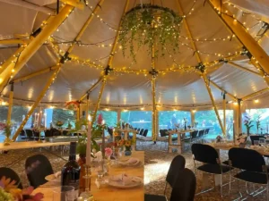 Firmaarrangement og teambuilding i stort tipitelt pyntet med lys og blomster